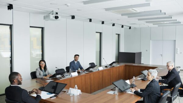 Ondernemers bespreken AI implementatie kosten tijdens zakelijke vergadering met laptops en documenten