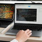 Developer bekijkt AI-gegenereerde code op twee schermen, developer rol AI zichtbaar in workflow