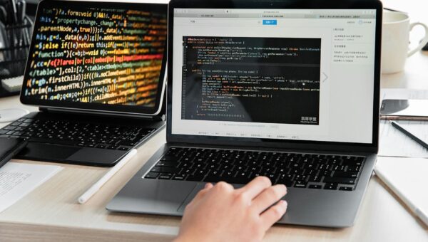 Developer bekijkt AI-gegenereerde code op twee schermen, developer rol AI zichtbaar in workflow