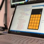 Designer bekijkt Figma componenten op scherm naast code-editor voor design system opzetten